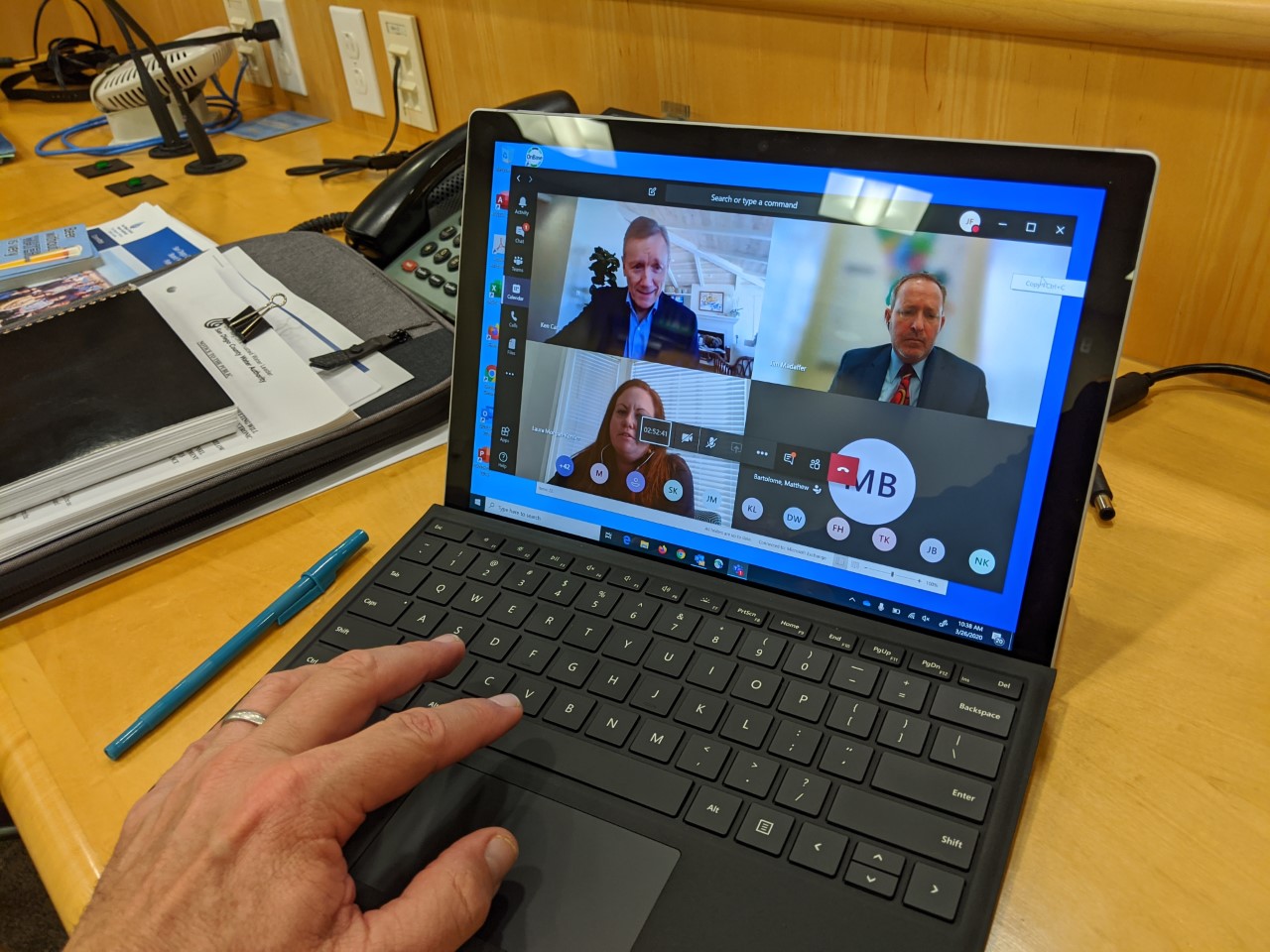 Water Authority board member looks up at a virtual meeting screen in the board room.