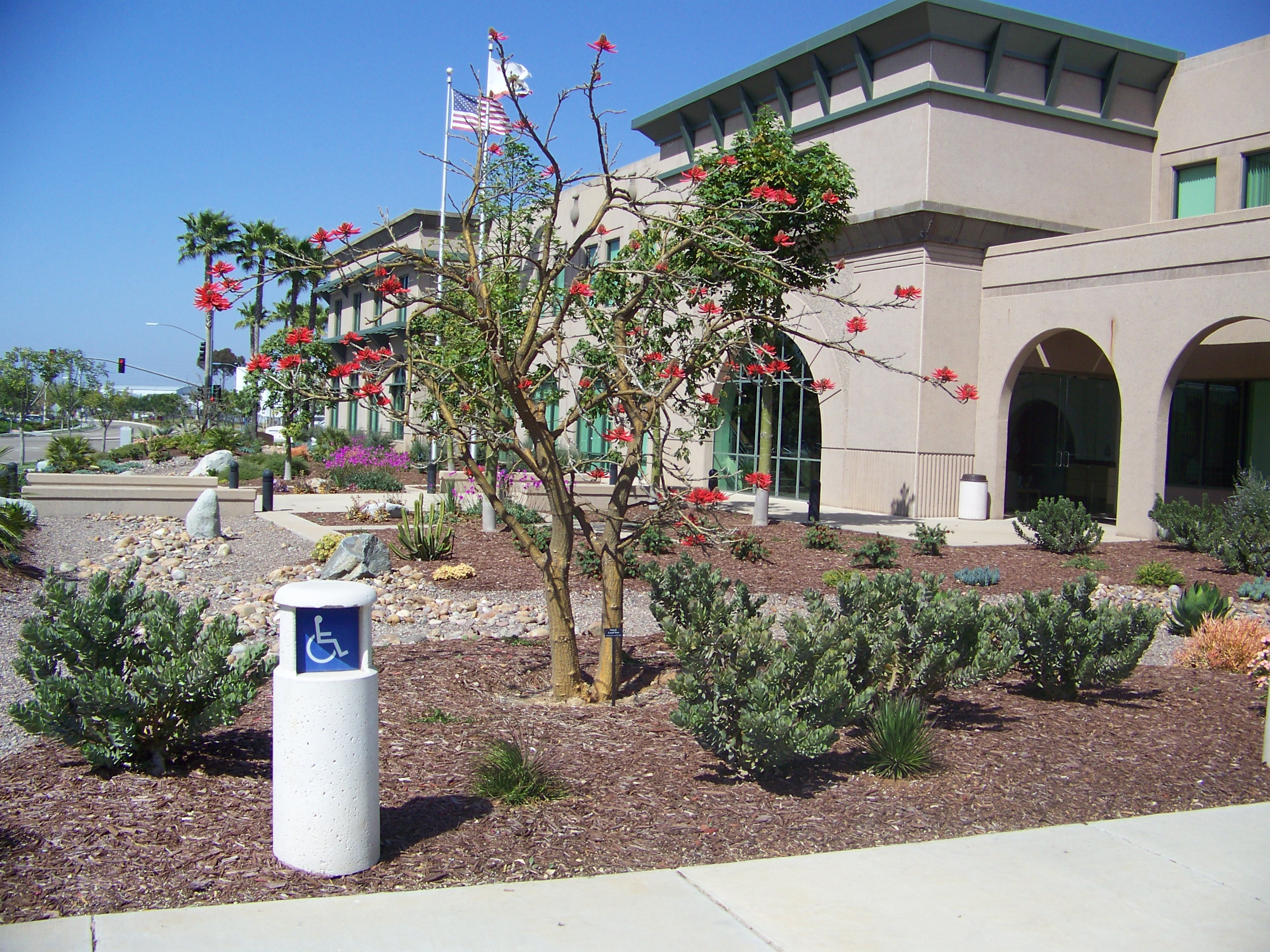 Building lobby with reception desk, check-in and check-out screen and transparent shields at the counter.